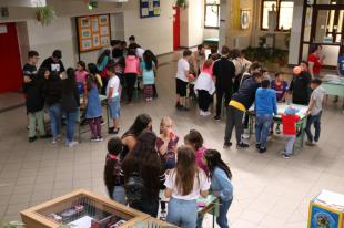 A II. János Pál Általános Iskola és Óvoda aulájában az asztalok körül, csoportokban tevékenykednek a diákok.