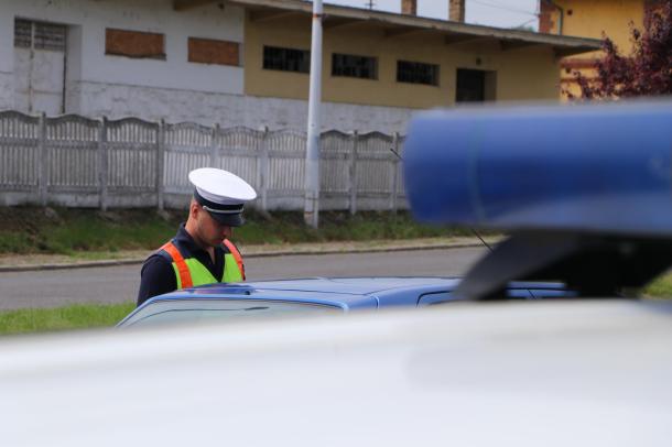 Az Ózdi Rendőrkapitányság közlekedésrendészeti osztályának egyik dolgozója ellenőrzi egy kék autó vezetőjét.