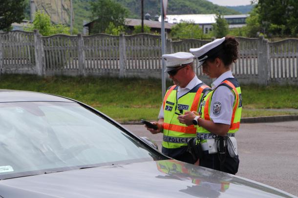 A rendőrök közúti ellenőrzés keretében vizsgálják egy jármű sofőrjének adatait.