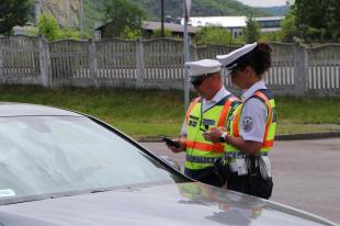 A rendőrök közúti ellenőrzés keretében vizsgálják egy jármű sofőrjének adatait.