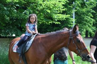 Az egyik óvodás kislány a ló hátán.