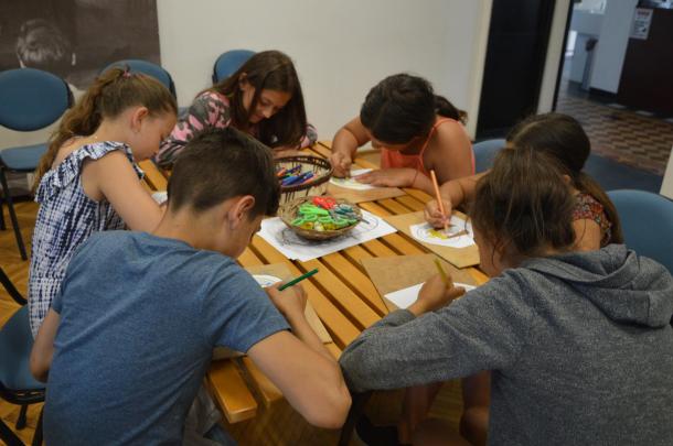 A tanulók egy asztalnál rajzolnak a múzeumban.