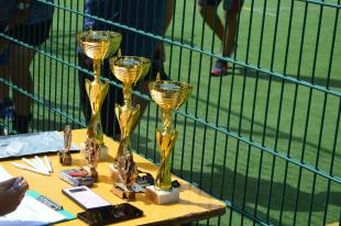 Egymás mellett sorakoznak a kupák, melyeket a nyertesek kaptak az „Együtt a rasszizmus ellen” kispályás labdarúgó tornán.