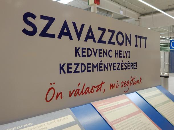 „Szavazzon itt kedvenc helyi kezdeményezésére” Ön választ, mi segítünk tábla a Brassói úti bevásárlóközpontban.