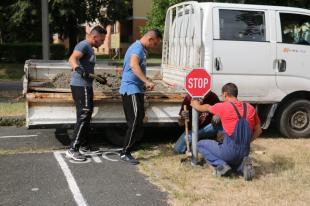 Az Ózdi Városüzemeltető Intézmény munkatársai betonozzák a táblákat.