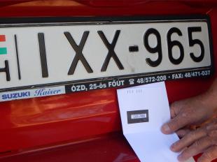 A piros Suzuki rendszámát összehasonlítja a hivatalos levélben érkezett fotóval.