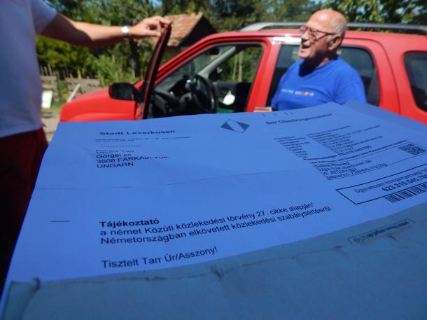 A német hatóságtól érkezett levél, háttérben az autó tulajdonosa.