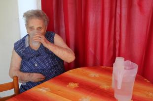 A Kézenfogva Szociális Szolgáltató Központ társalkodójában citromos vizet iszik egy lakó.