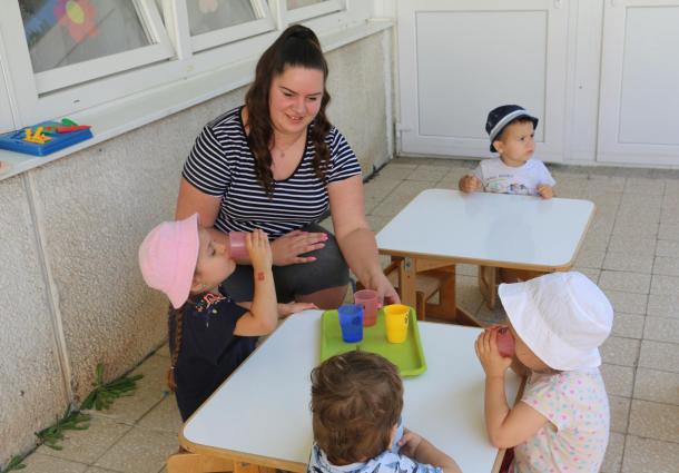 Vizet isznak a bölcsődés gyerekek az asztaloknál.