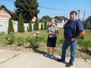 Csikainé Mihalik Éva református lelkipásztor és Kisbenedek Vilmos kivitelező beszélgetnek a templomkertben.
