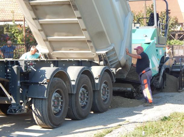 Zajlik a munkavégzés a Gubonnai úton, öntik a teherautóról a betont.