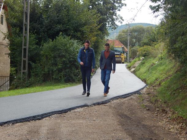 Dr. Csuzda Gábor területi képviselő és Janiczak Dávid polgármester sétál a vadonatúj aszfaltos úton.