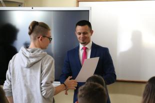 A tanuló átveszi Ózd város polgármesterétől a jutalomért járó oklevelet.