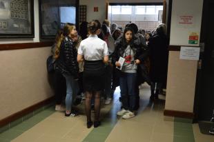 Csoportosan állnak a tanulók a tornaterem előtt, indulásra készen hogy körbenézzenek az épületben.