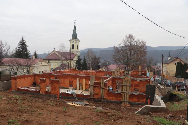 Távoli kép az építkezési területről, háttérben a templommal.
