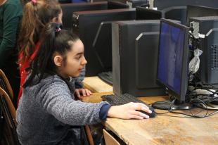 Közeli kép az egyik diákról, aki a számítógép előtt ül.