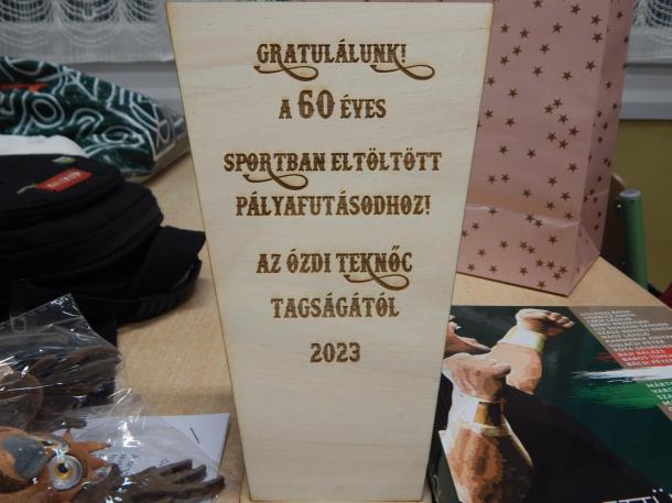 Fából készült emlékplakett a klubtól. „Gratulálunk! A 60 éves sportban eltöltött pályafutásodhoz az Ózdi Teknőc tagságától 2023” felirattal.