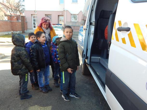 Gyerekek szállnak be a rendőrségi csapatszállító járműbe.