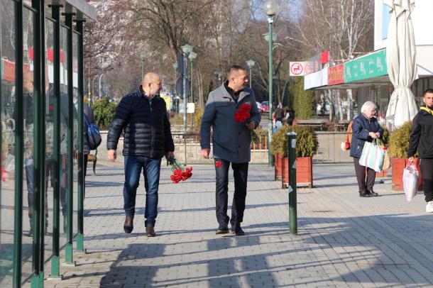 Kiss Sándor és Molnár Zsolt virágcsokorral a kezükben sétálnak a Városház téren.