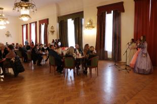 A Pilvax Kávéházban ülők hallgatják az ÓMI Zenés Színház tagjainak énekes produkcióját.