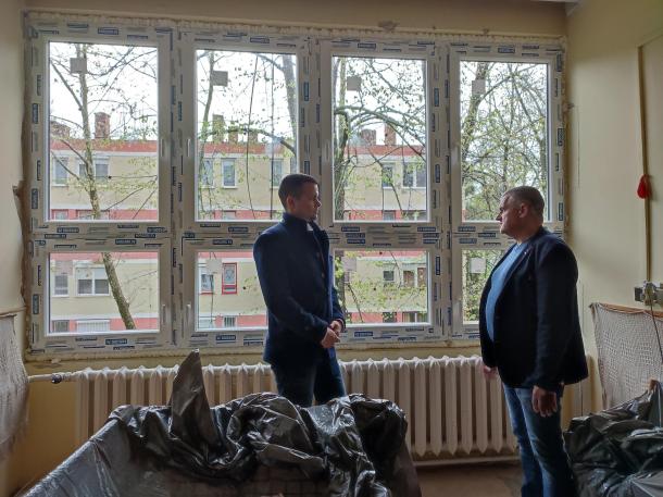 Janiczak Dávid, városunk polgármestere és Angyal Béla, területi képviselő beszélgetnek a Szabolcs közi idősotthon új ablakai előtt.