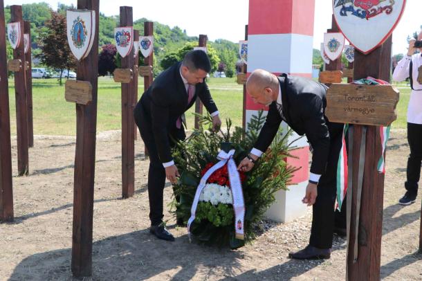 Janiczak Dávid polgármester és Kiss Sándor önkormányzati képviselő elhelyezi a koszorút az emlékmű előtt.