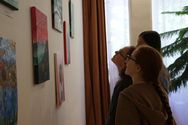 Diákok szemlélik a festményeket.