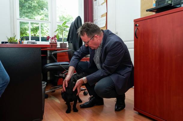 Bukovinszky Zsolt az irodában játszik a kutyával.