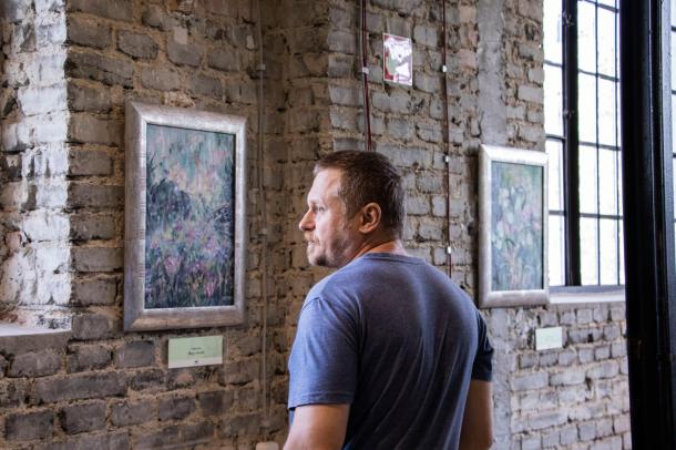 Egy férfi nézi a kiállítás egyik alkotását.
