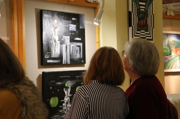 Két hölgy Ildikó egyik festményét nézi.