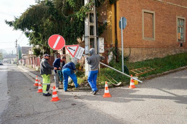 A szakemberek behelyezik a táblát a lyukba.