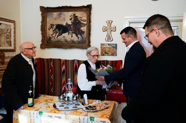 Janiczak Dávid polgármester átad egy virágcsokrot az ünnepeltnek.