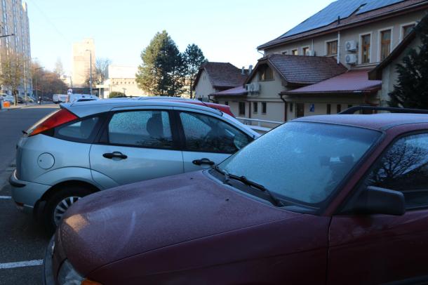 Lefagyott szélvédőjű autók a parkolóban.