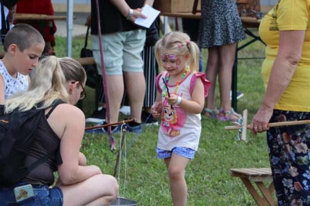 Egy kislány botra erősített fonállal horgászik a Neutrik családi napján.