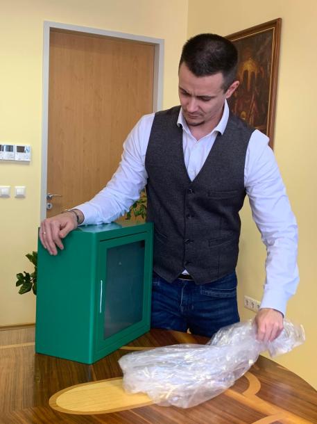 Janiczak Dávid polgármester kibontja a defibrillátorok tároló dobozát.