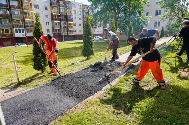 Aszfaltot terítenek a járdára a szakemberek.