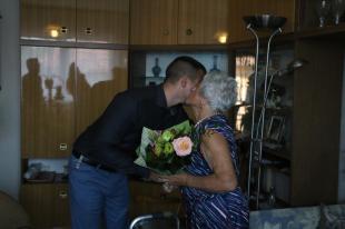 Ózd Polgármestere átadja a virágot Roszjár Lajosnénak Kilencvenedik születésnapja alkalmából.