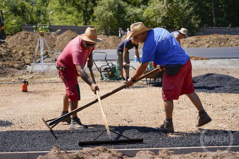 A szakemberek az aszfaltot egyengetik.