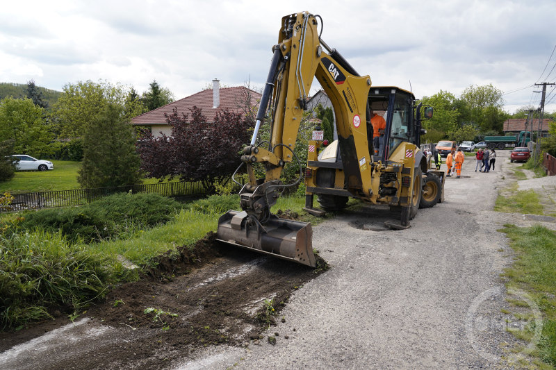 Az útszéli földet egyengetik el géppel.