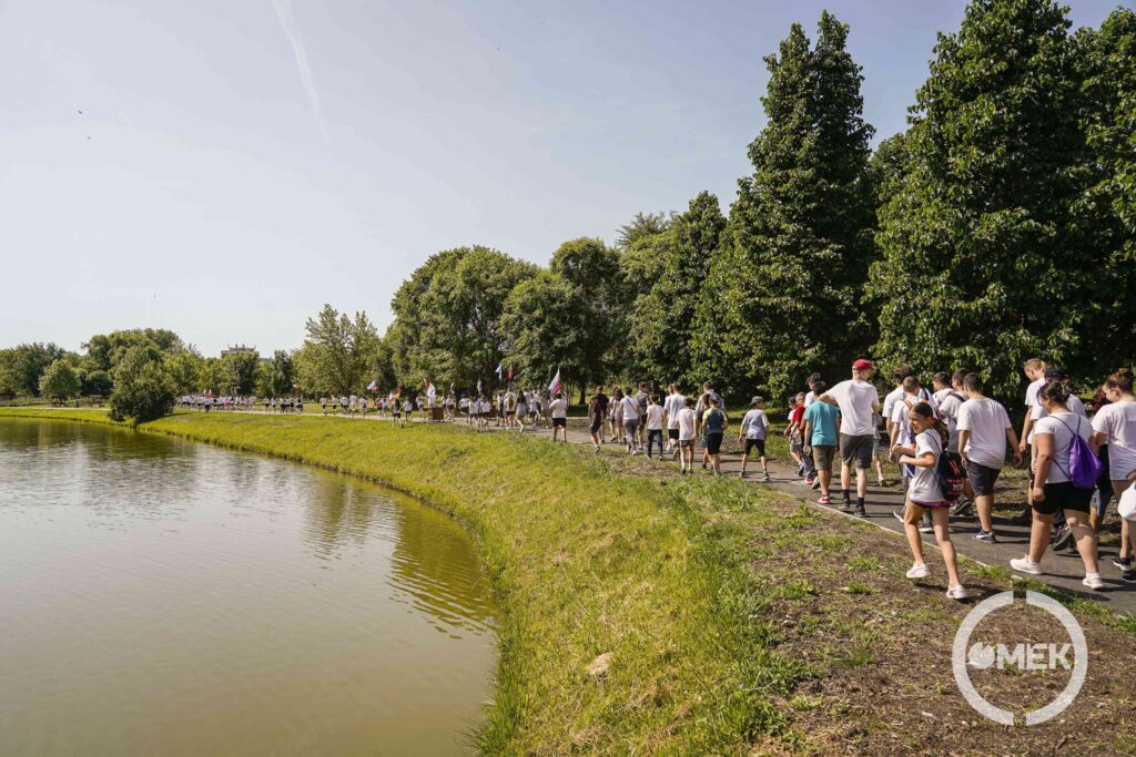 Hosszú sorban futnak a diákok a tó partján.