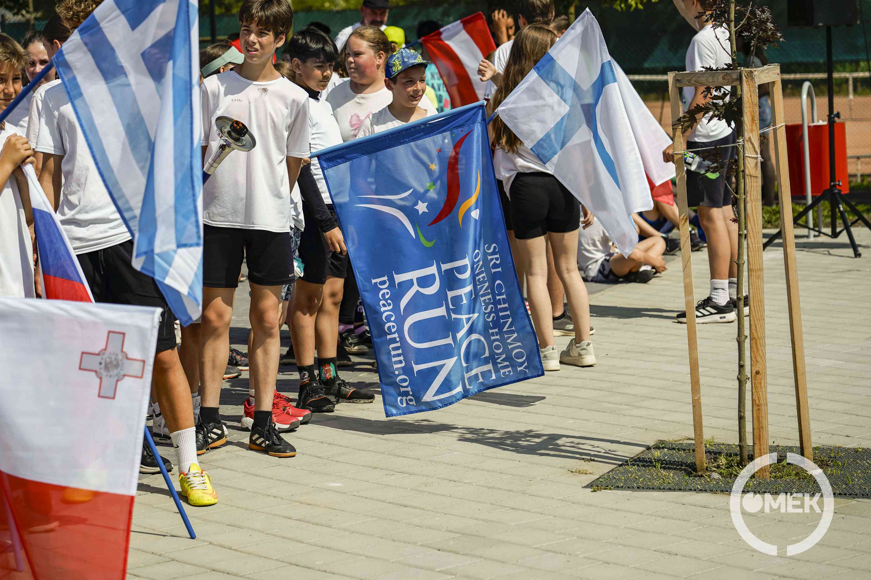 Zászlókat lobogtatva futnak a diákok.