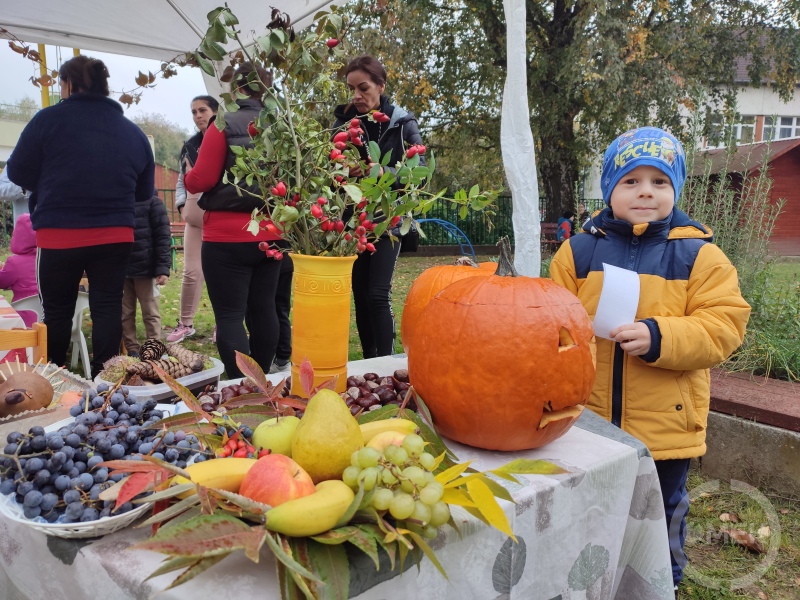 Egy kisfiú áll az asztal mellett.
