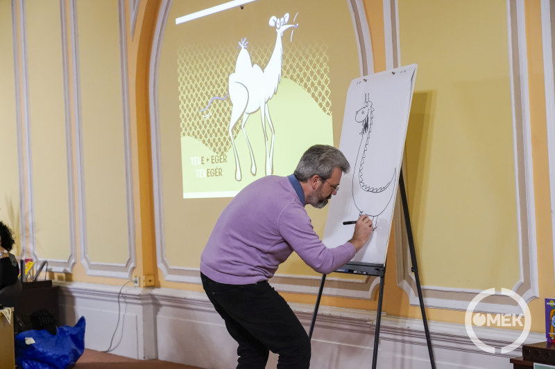 Dudás Győző krokodilfejű és zsiráfnyakú zsirilt rajzol.