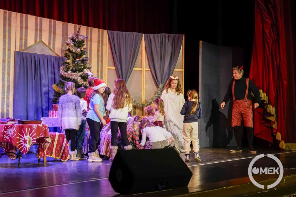 A gyerekek a színészeknek segítenek a színpadon.