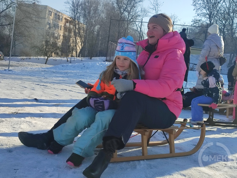 Egy anyuka a kislányával a szánkón.