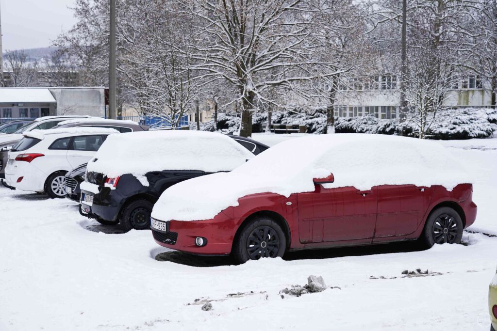 Hóval borított kocsik állnak a parkolóban.