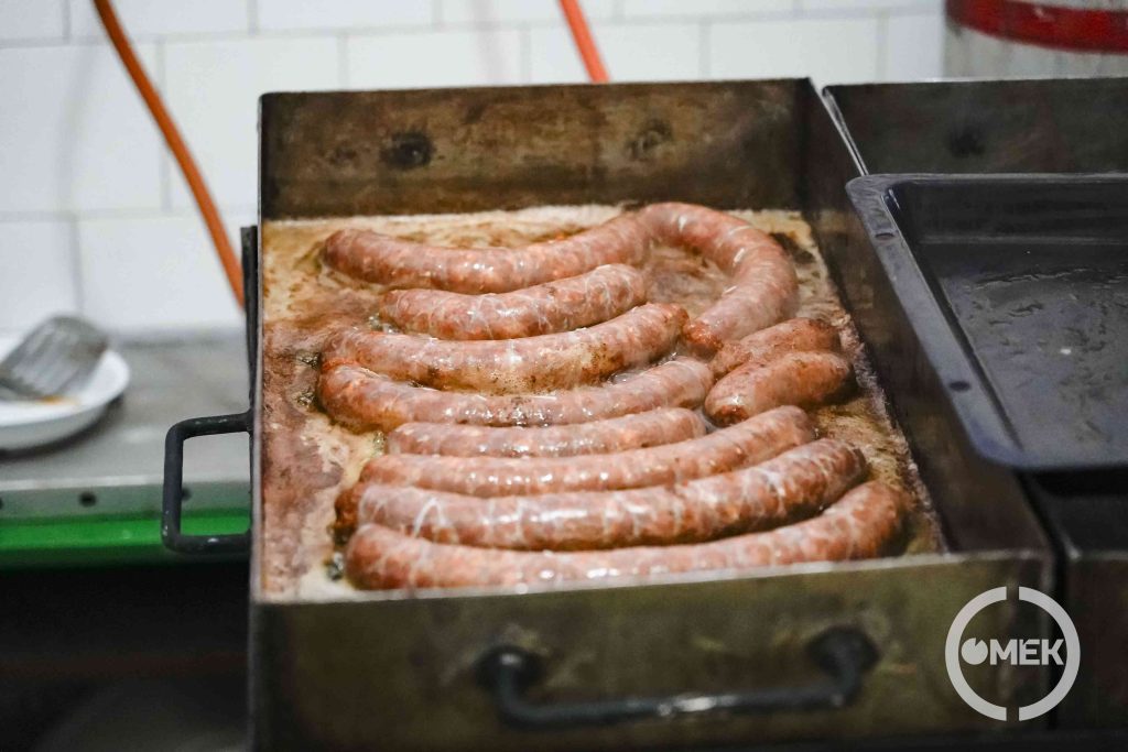 Sülnek a kolbászok az iskola konyháján.