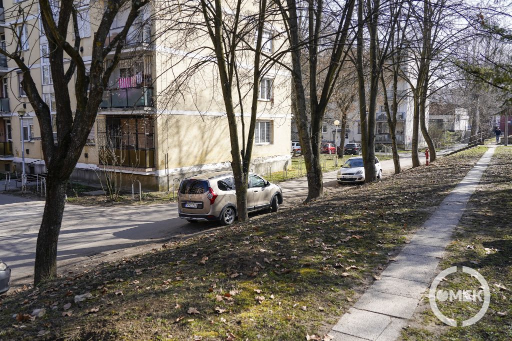 Az út szélén álló autók megnehezítik a közlekedést.