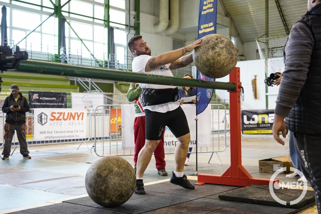 A kőgolyót átdobják a rúd felett.