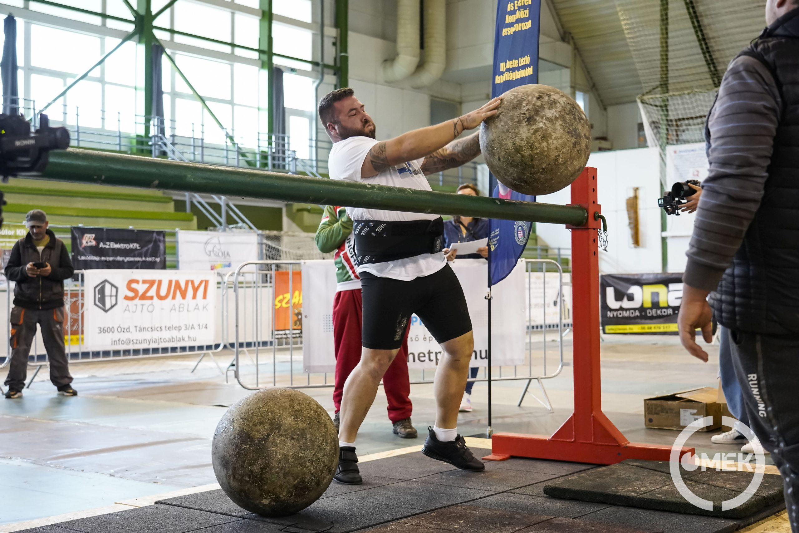 A kőgolyót átdobják a rúd felett.